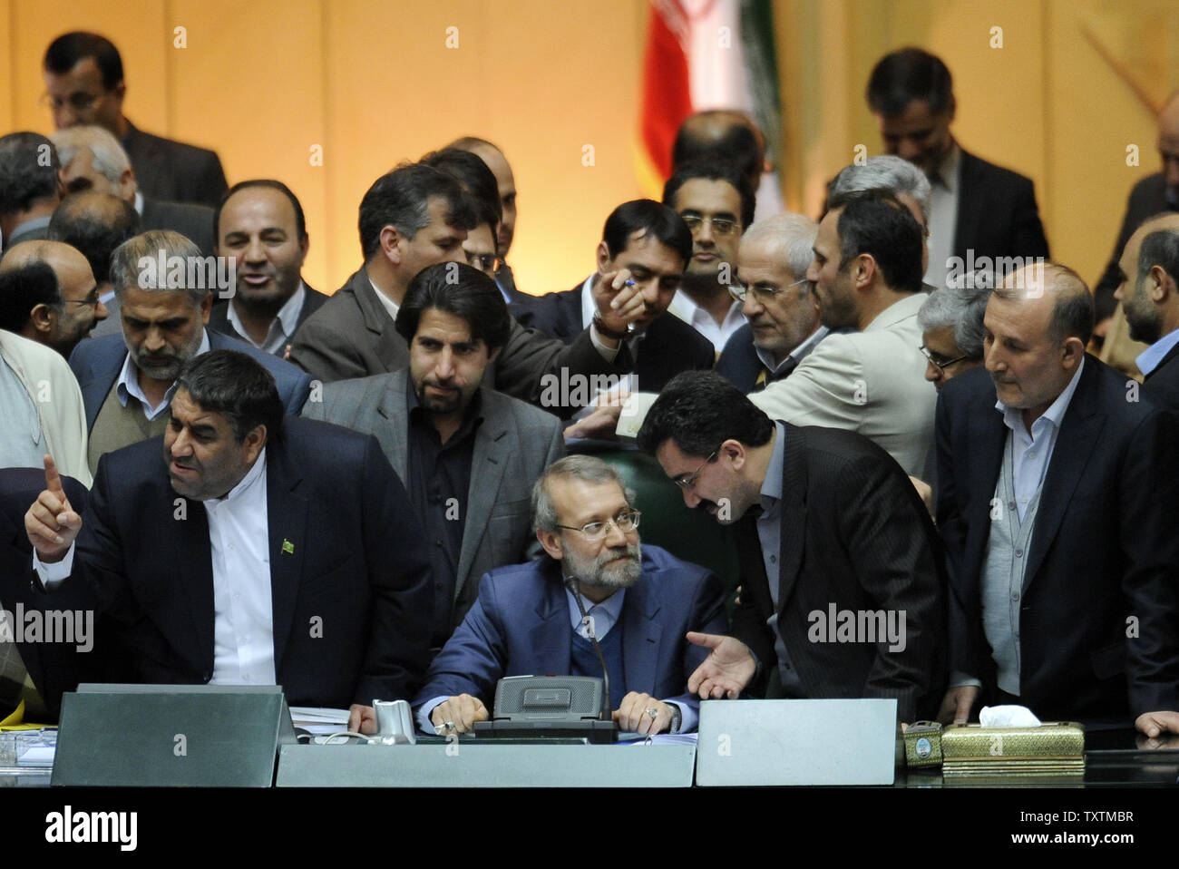 Iranian Parliamentary speaker Ali Larijani (C) is surrounded by MP's during the impeachment of the labor minister Abdolreza Sheikholeslami, unseen, at the parliament in Tehran, Iran on February 3, 2013. Out of 272 lawmakers in the parliament on Sunday, 192 voted against the labor minister. The main reason behind the MP's decision to dismiss the minister was Sheikholeslami's refusal  to remove former Tehran prosecutor general Saeed Mortazavi from his post as the director of the Social Security Organization.     UPI/Maryam Rahmanian Stock Photo