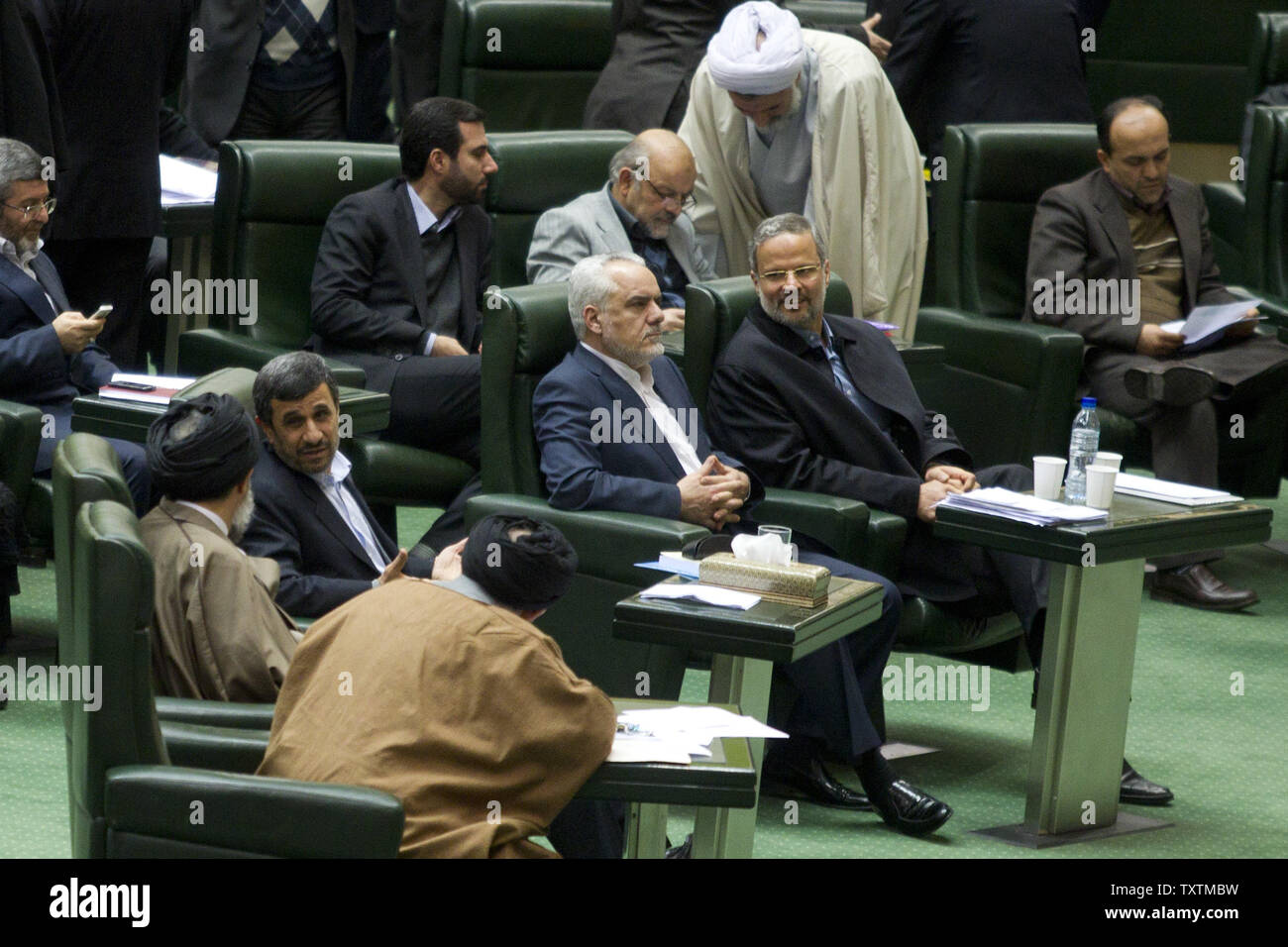 (L-R) Iranian President Mahmoud Ahmadinejad speaks to unidentified lawmakers as his Vice President, Mohammad Reza Rahimi, sits next to labor minister Abdolreza Sheikholeslami (R) during  impeachment of Sheikholeslami at the parliament in Tehran, Iran on February 3, 2013. The main reason behind MP's decision to dismiss the minister was Sheikholeslami's refusal  to remove former Tehran prosecutor general Saeed Mortazavi from his post as the director of the Social Security Organization.     UPI/Maryam Rahmanian Stock Photo