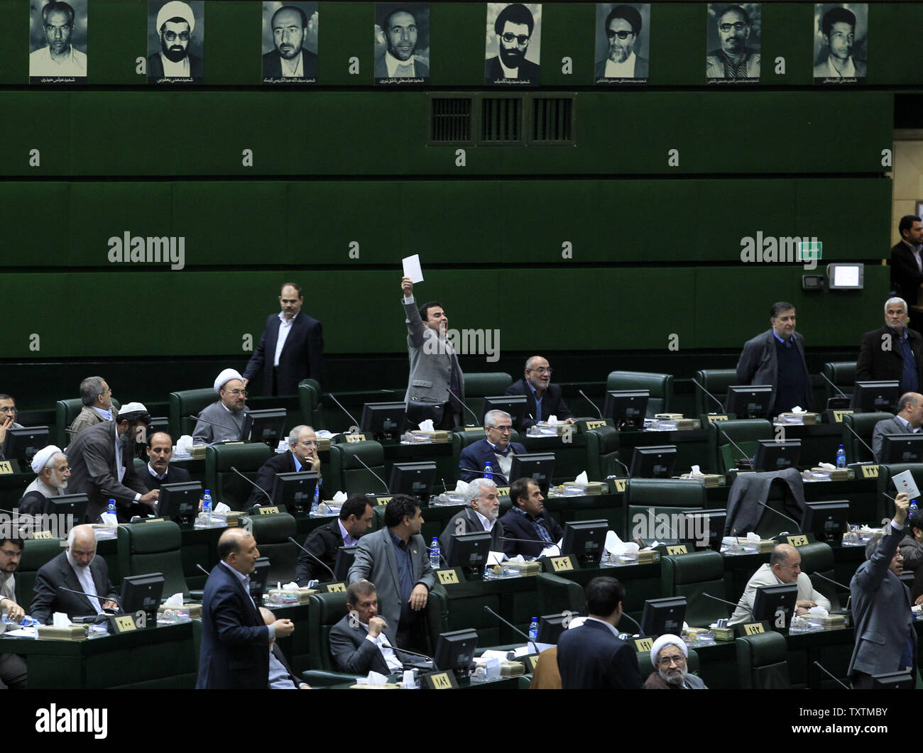 A member of Iranian parliament  protests while President Mahmoud Ahmadinejad (R) speaks during the impeachment of the labor minister , Abdolreza Sheikholeslami, unseen, at the parliament in Tehran, Iran on February 3, 2013. Out of 272 lawmakers in the parliament on Sunday, 192 voted against the labor minister. The main reason behind the MP's decision to dismiss the minister was Sheikholeslami's refusal  to remove former Tehran prosecutor general Saeed Mortazavi from his post as the director of the Social Security Organization.     UPI/Maryam Rahmanian Stock Photo