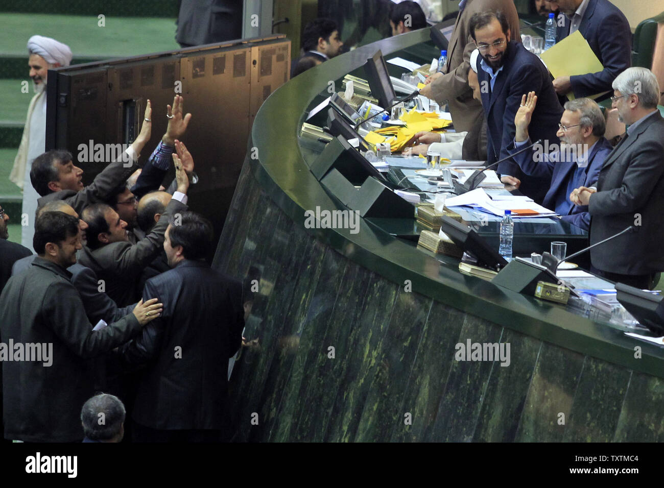 Members of Iranian parliament greet Iranian Parliamentary Speaker Ali Larijani (C) after the result of the impeachment of the labor minister Abdolreza Sheikholeslami, unseen, was announced at the parliament in Tehran, Iran on February 3, 2013. Out of 272 lawmakers in the parliament on Sunday, 192 voted against the labor minister. The main reason behind the MP's decision to dismiss the minister was Sheikholeslami's refusal  to remove former Tehran prosecutor general Saeed Mortazavi from his post as the director of the Social Security Organization.     UPI/Maryam Rahmanian Stock Photo