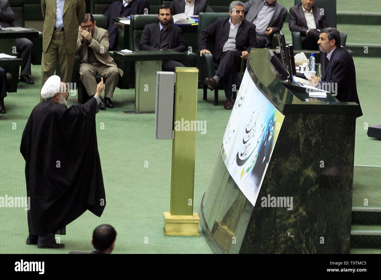 A member of the Iranian parliament protests while Iranian President Mahmoud Ahmadinejad (R) speaks during the impeachment of the labor minister Abdolreza Sheikholeslami, unseen, at the parliament in Tehran, Iran on February 3, 2013. Out of 272 lawmakers in the parliament on Sunday, 192 voted against the labor minister. The main reason behind the MP's decision to dismiss the minister was Sheikholeslami's refusal  to remove former Tehran prosecutor general Saeed Mortazavi from his post as the director of the Social Security Organization.     UPI/Maryam Rahmanian Stock Photo