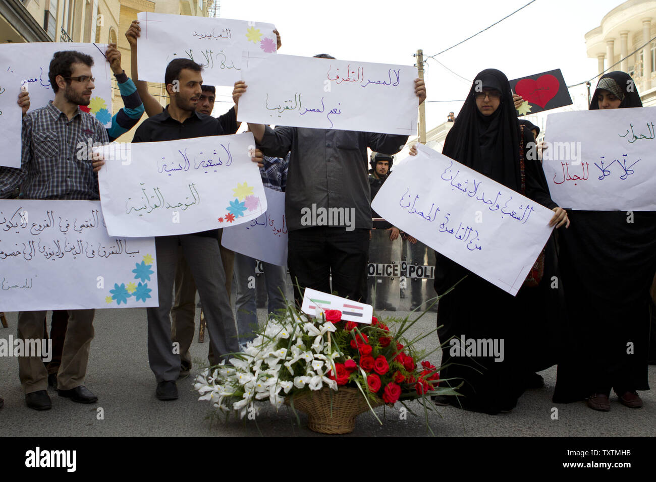 Iranian students hold placards in front of the Representative Office of  Egypt in Tehran, Iran on April 9, 2013. Iranian university students decided  to deliver flowers to the Head of Egypt's interest
