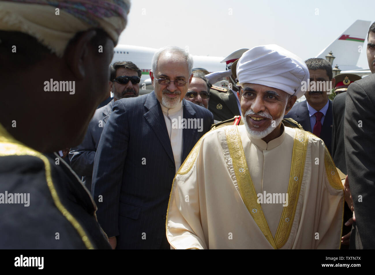 Oman's Sultan Qaboos bin Sa‘id is greeted by Omani officials in Tehran during his welcome ceremony at Mehrabad Airport as Iranian foreign minister Mohammad Javad Zarif stands behind him on August 25, 2013 in Tehran, Iran. The Omani monarch is the first head of state to visit Tehran since President Hassan Rouhani took office on August 4.     UPI/Maryam Rahmanian Stock Photo