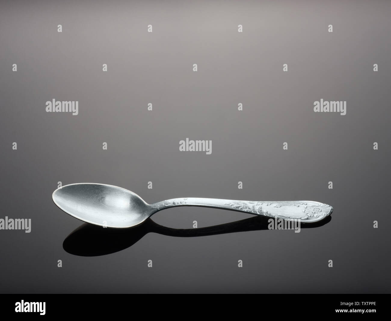 https://c8.alamy.com/comp/TXTPPE/one-upronickel-teaspoon-on-gray-background-with-gradient-and-reflection-TXTPPE.jpg