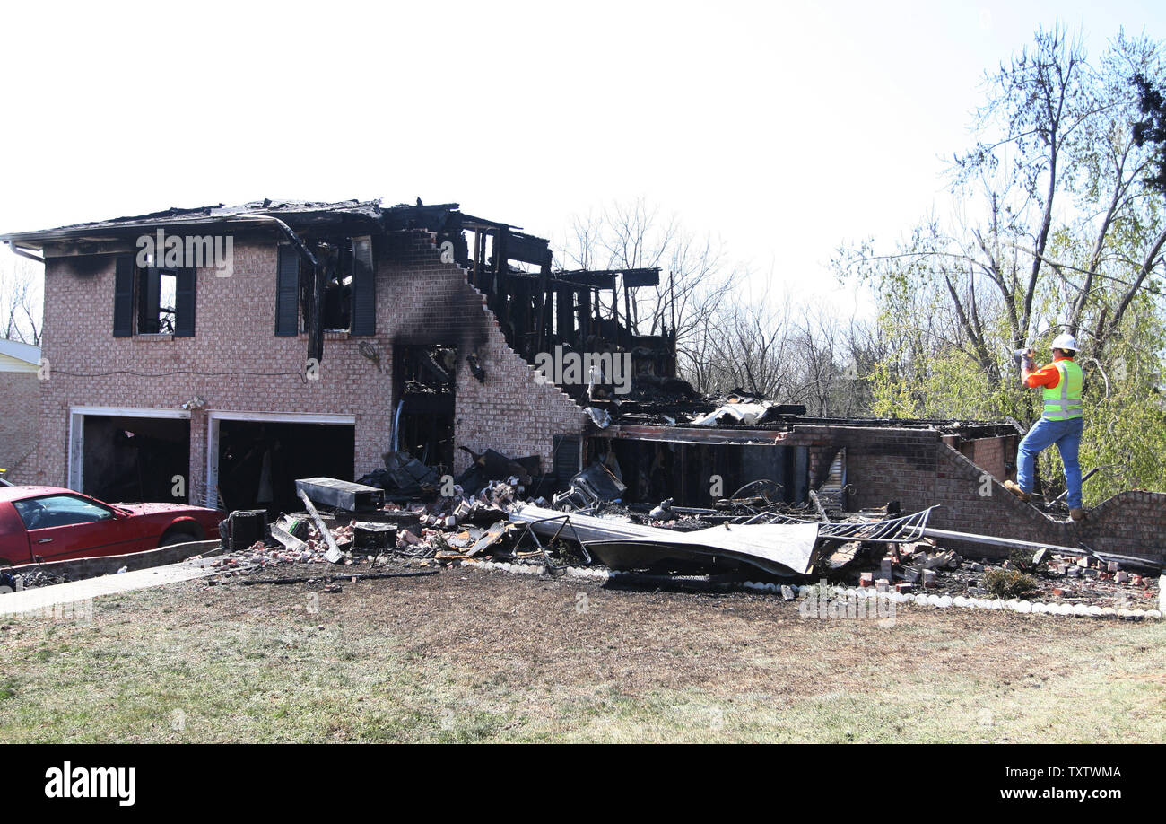 An investigator takes photographs of a burned home where an early