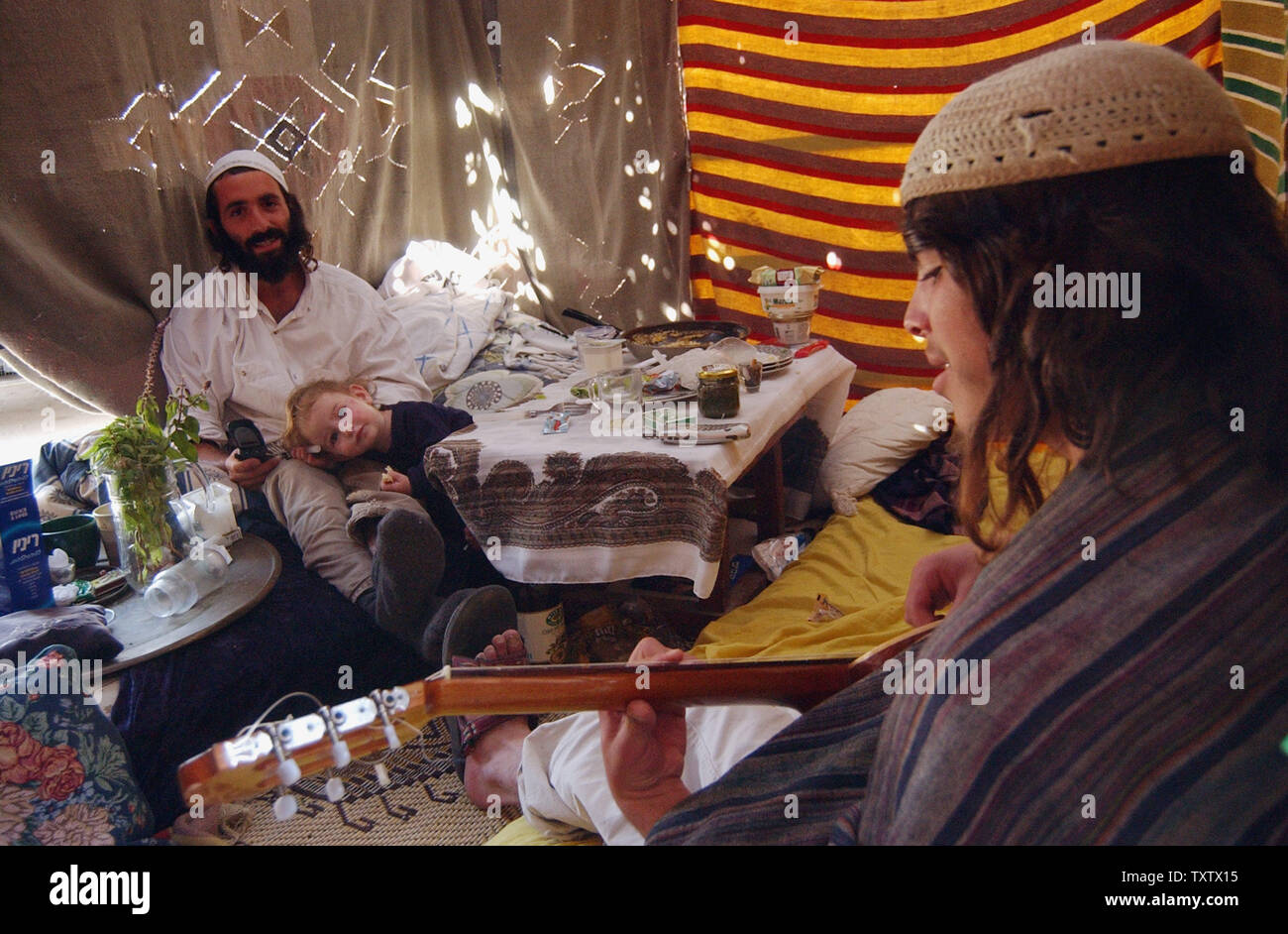 An Israeli settler plays a guitar in a sukka for the religious holiday, Sukkot,  in the Biblical city of Hebron, October 14, 2003, traditionally believed to be the burial site of Abraham, Isaac, Jacob and their wives.  (UPI Photo/Debbie Hill) Stock Photo