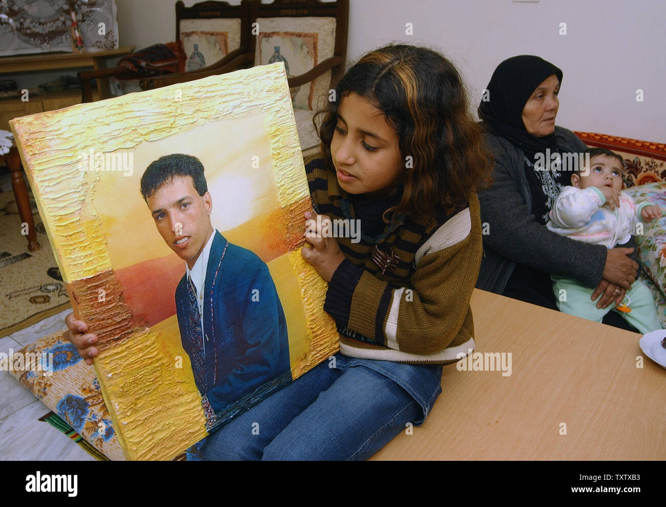 Kasan Suwaid holds a photo of her cousin, kidnapped Israeli soldier, Omar Suwaid, at his home in the Bedouin village Salama in northern Israel, January 27, 2004. Omar was kidnapped in October 2000, with two soldiers whose bodies will be returned to Israel in a controversial  prisoner swap brokered by Germany. Israel will receive the bodies of three slain Israeli soldiers and an Israeli businessman in exchange for releasing 59 bodies of Hizbollah fighters and more than 400 Arab prisoners. (UPI Photo/Debbie Hill) Stock Photo