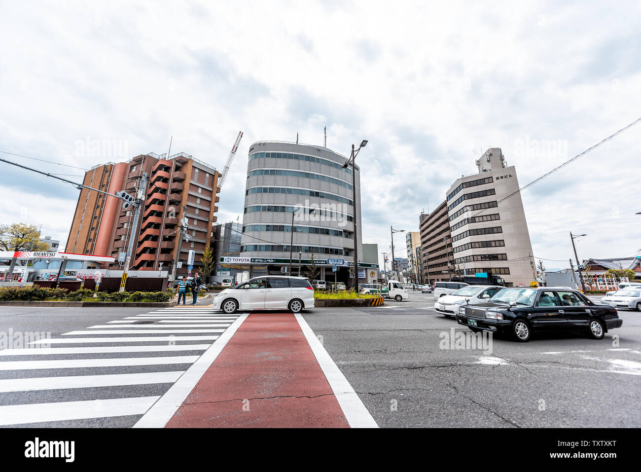 Kyoto, Japan - April 17, 2019: Cars in traffic outside on cloudy day in downtown city on Gojo dori street and cityscape of modern buildings Stock Photo