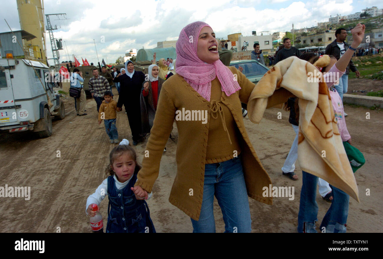 Palestinians rush to buses carrying released Palestinian prisoners at the Tulkarem checkpoint, February 21, 2005. Some 500 prisoners were freed by Israel in an act of goodwill towards newly elected Palestinian President Mahmoud Abbas. Each prisoner signed a pledge  not to  engage in terrorist activity in the future. (UPI Photo/Debbie Hill) Stock Photo