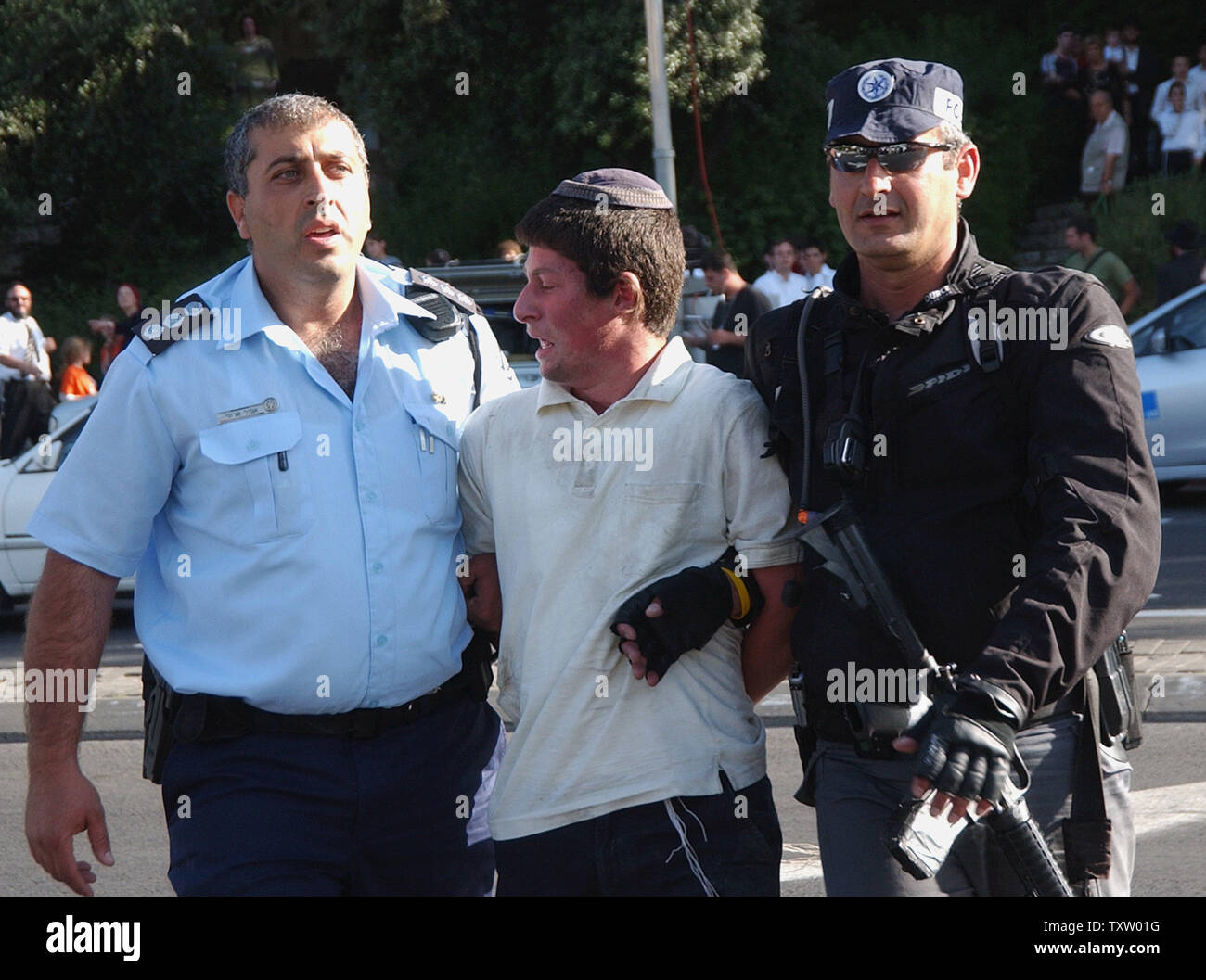 Israeli police arrest an anti-disengagement protester after he helped block a busy intersection at the entrance to Jerusalem during rush hour, May 16, 2005. Israeli right-wing demonstrators blocked major traffic junctions throughout the country in protest of Israeli Prime Minister Ariel Sharon's plan to withdraw all Jewish settlements out of Gaza in August. (UPI Photo/Debbie Hill) Stock Photo