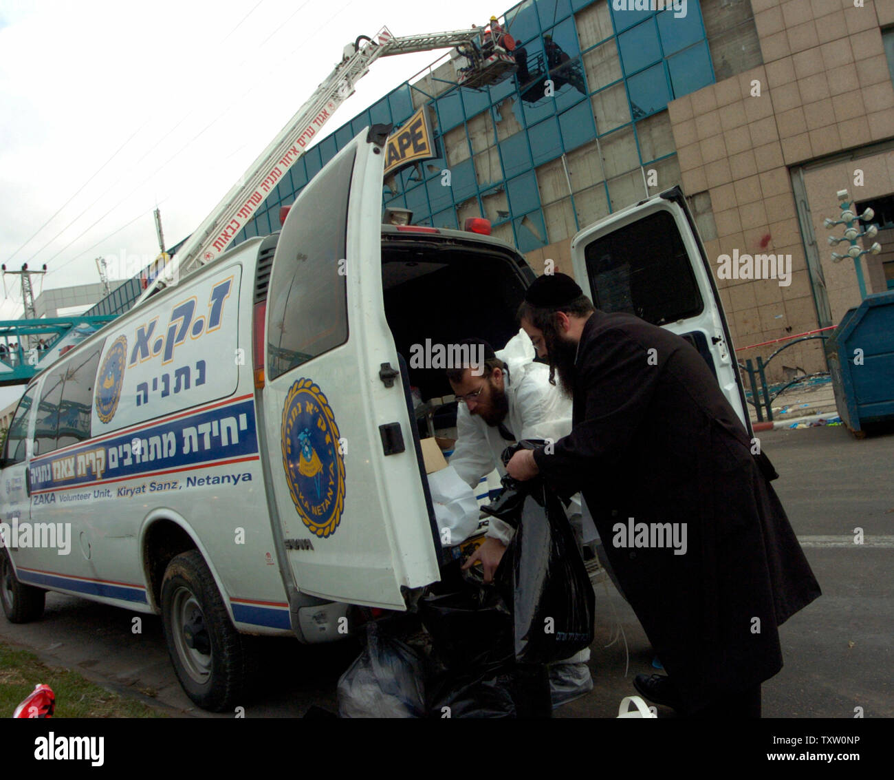 Israeli Ultra-Orthodox Zaka rescue volunteers remove bags filled with human  debris from a blast from a suicide bomber that killed five at a shopping  mall in Netanya, Israel on December 5, 2005.