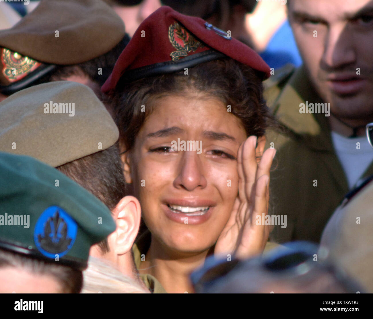 An Israeli soldier cries during the funeral of her comrade Nimrod Cohen in the military section of the Mt. Herzl cemetery on July 13, 2006 in Jerusalem. Cohen was one of the Israeli soldiers killed by Hezbollah gunmen on July 12, 2006.  (UPI Photo/Joerg Waizmann) Stock Photo