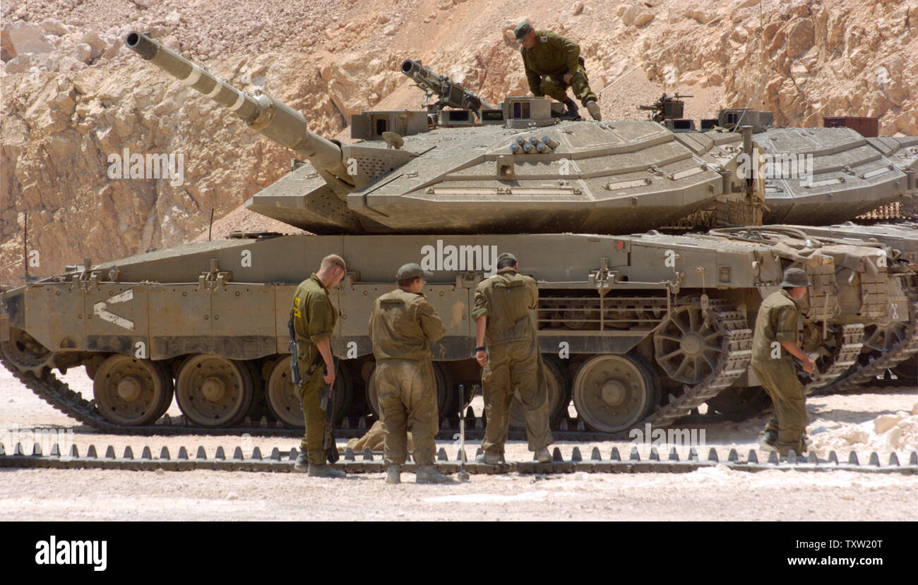 Israeli soldiers prepare tanks to enter Lebanon at a staging position