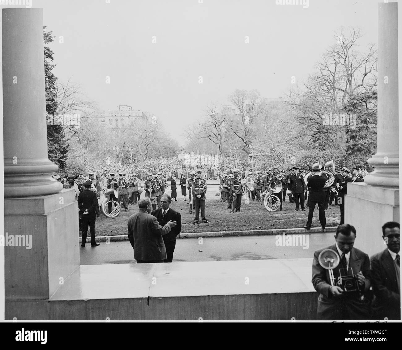 A military band standing on the front lawn of the White House; a large crowd is gathered in Jackson Park across the street. President Truman and Vice President-elect Alben W. Barkley had just returned to Washington after their victory in the 1948 election. Stock Photo