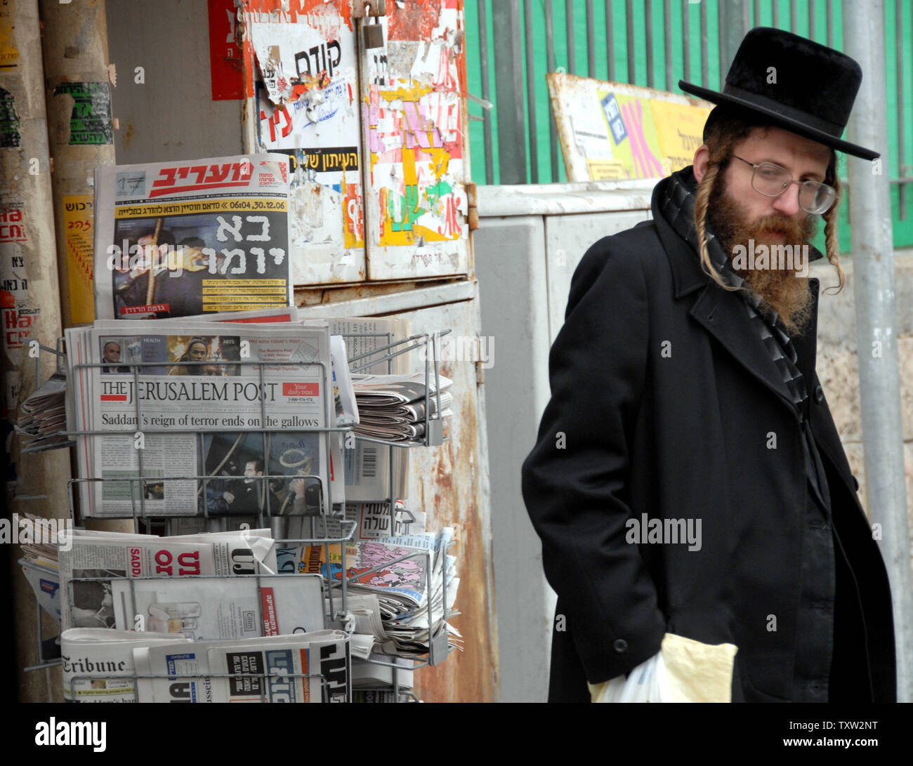 An Orthodox Jew stands by Israeli newspapers in downtown Jerusalem announcing the execution of former Iraqi President Saddam Hussein, December 31, 2006.  (UPI Photo/Debbie Hilll) Stock Photo