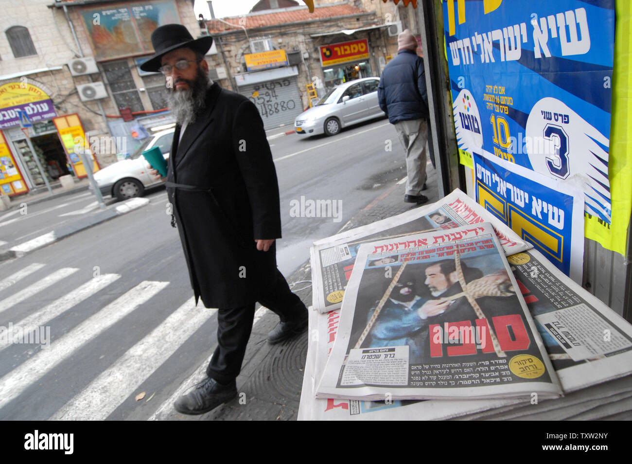 An Ultra-orthodox Jew walks by Israeli newspapers reading 'His End' with a photograph of  the execution of former Iraqi President Saddam Hussein, December 31, 2006, in Jerusalem.  (UPI Photo/Debbie Hilll) Stock Photo
