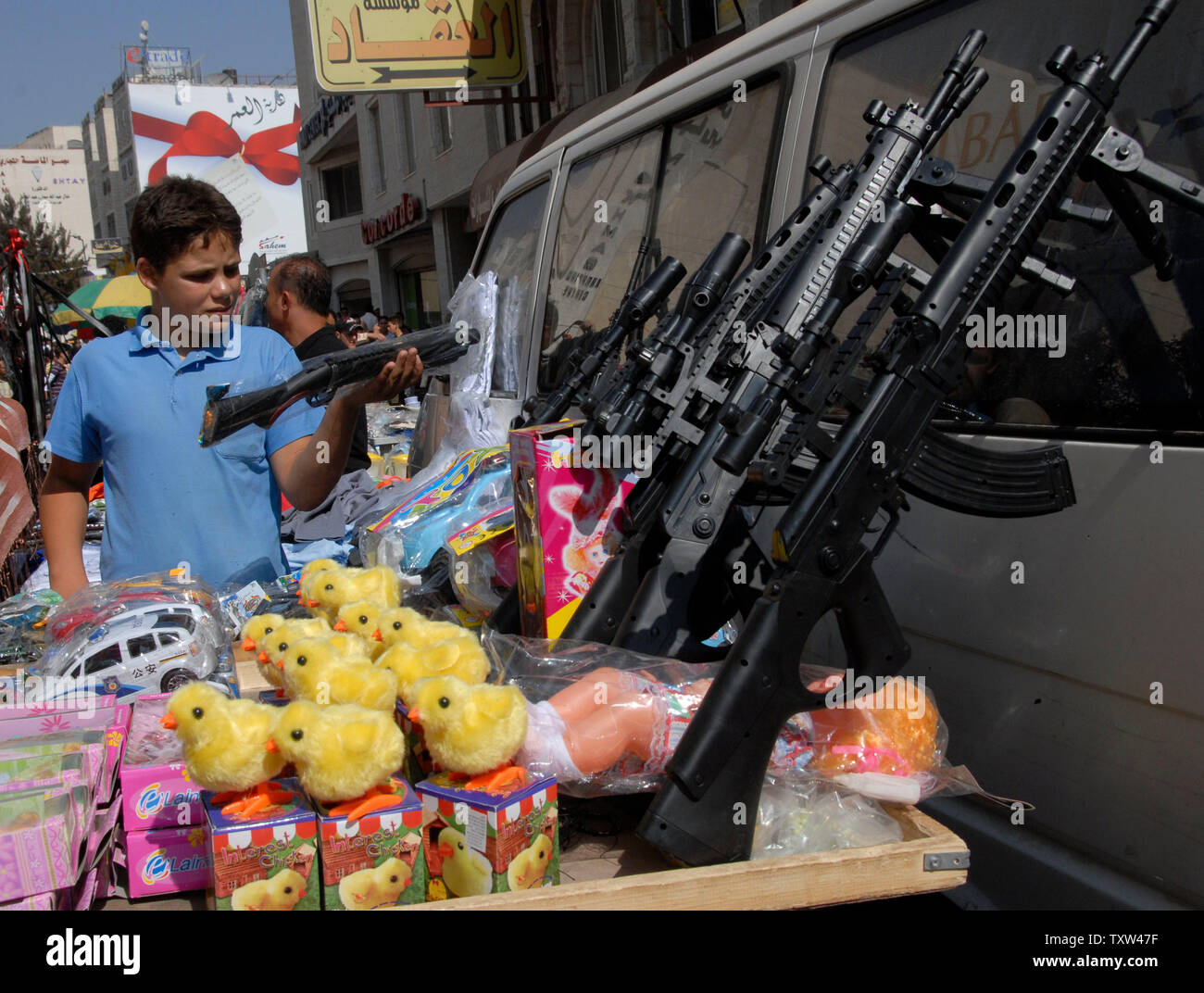 A Palestinian boy looks at a toy gun at a Ramadan market in central Ramallah, West Bank, October 10, 2007. Palestinians buy toy guns as gifts for children to mark the end of the holy month of Ramadan and to celebrate the three day holiday of Eid al-Fitr. (UPI Photo/Debbie Hill) Stock Photo