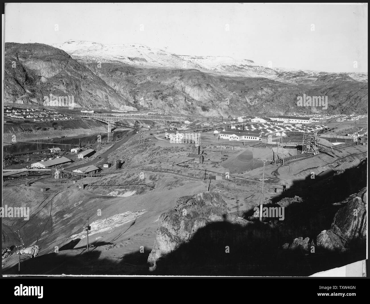 A three-view panorama of the development from top of east abutment.; Scope and content:  Photograph from Volume Two of a series of photo albums documenting the construction of the Grand Coulee Dam and related work on the Columbia Basin Project. General notes:  This image is part of a panoramic view which includes items 933, 934, and 935. The original image measures approximately 27 inches in width. Stock Photo