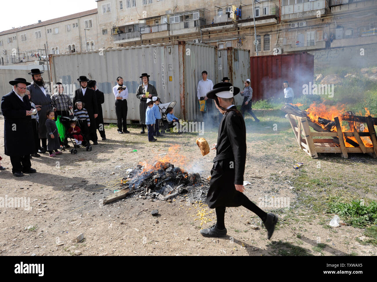 An Ultra-Orthodox Jewish boy throws a loaf of bread into a fire to burn leavened products before the start at sundown of the Passover festival in the religious neighborhood of Mea Shearim in Jerusalem, April 18, 2011. The Passover holiday commemorates the story of the ancient Israelites exodus from Egypt.  All leavened food is forbidden during the week-long holiday.  UPI/Debbie Hill Stock Photo