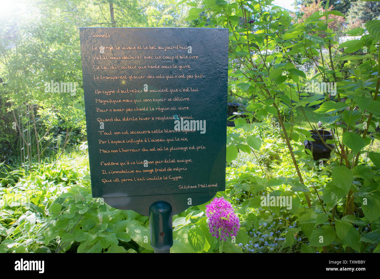 Someone planted a kind of commemorative plate in their garden. It is a poem by Stéphane Mallarmé called 'Sonnets'.  Niagara-On-The-Lake. Stock Photo