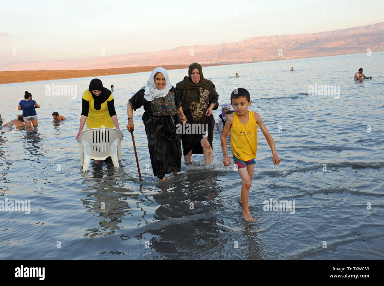 Palestinians walk out of the Dead Sea at Kalya Beach, West Bank, on the second day of the Muslim festival Eid al-Adha, November 7, 2011. The Dead Sea is among the top 10 finalists in the International New 7 Wonders of Nature Campaign, which will conclude on Friday, 11.11.11. UPI/Debbie Hill Stock Photo