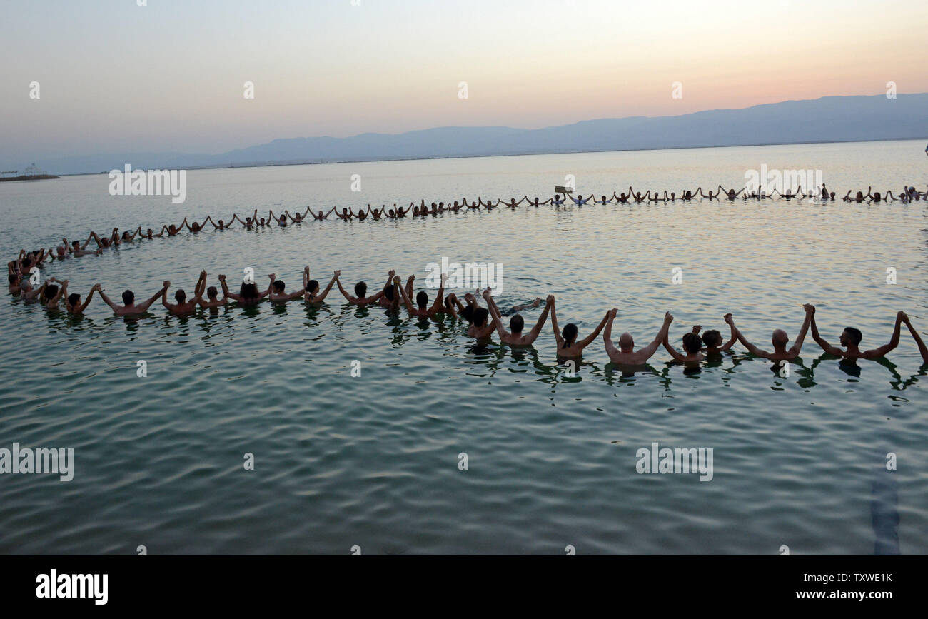Israeli and international environmental and social activists hold hands in the Dead Sea, during a protest float at dawn against the deterioration of the Dead Sea, in an event organized by U.S. photographer Spencer Tunick, not seen, at Ein Bokek, Israel, September 14, 2012. UPI/Debbie Hill Stock Photo