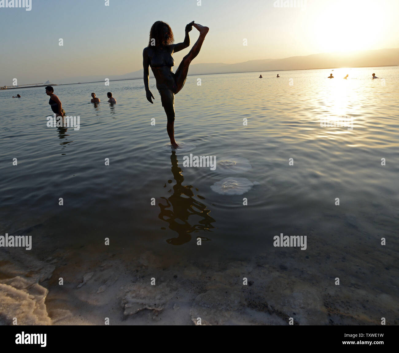 An Israeli does a yoga pose on a salt crust in the Dead Sea during an Israeli and international environmental and social  protest float at dawn against the deterioration of the Dead Sea,  Ein Bokek, Israel, September 14, 2012.  The  event was organized by U.S. photographer Spencer Tunick.  UPI/Debbie Hill Stock Photo