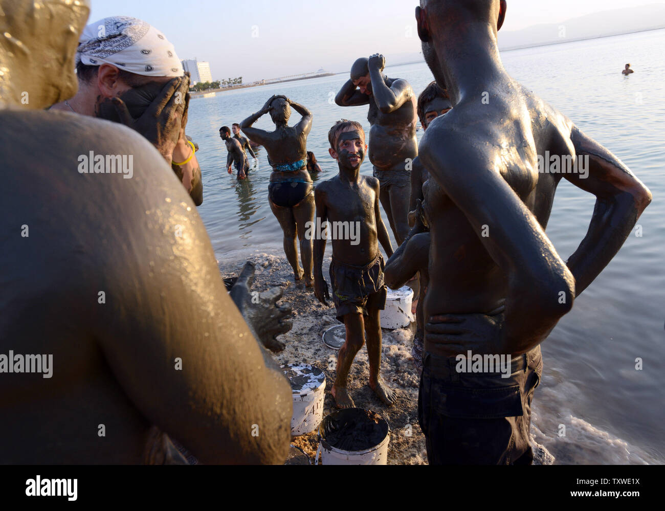 Israeli and international environmental and social activists apply black mud from the Dead Sea during a protest float at dawn against the deterioration of the Dead Sea, in an event organized by U.S. photographer Spencer Tunick, not seen, at Ein Bokek, Israel, September 14, 2012. UPI/Debbie Hill Stock Photo