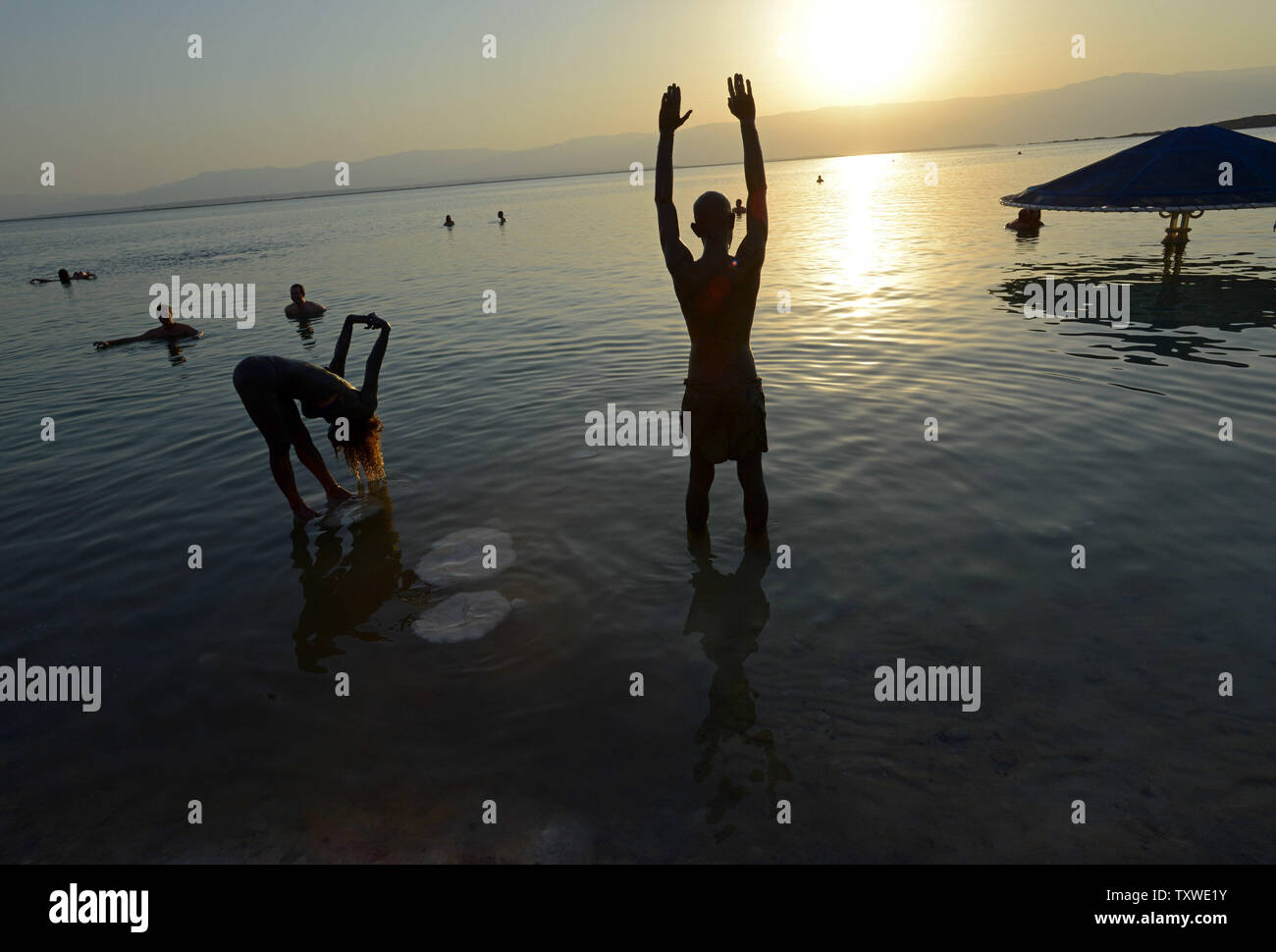 Israelis practice yoga poses on  salt crusts in the Dead Sea during an Israeli and international environmental  social  protest float at dawn against the deterioration of the Dead Sea,  Ein Bokek, Israel, September 14, 2012.  The  event was organized by U.S. photographer Spencer Tunick.  UPI/Debbie Hill Stock Photo
