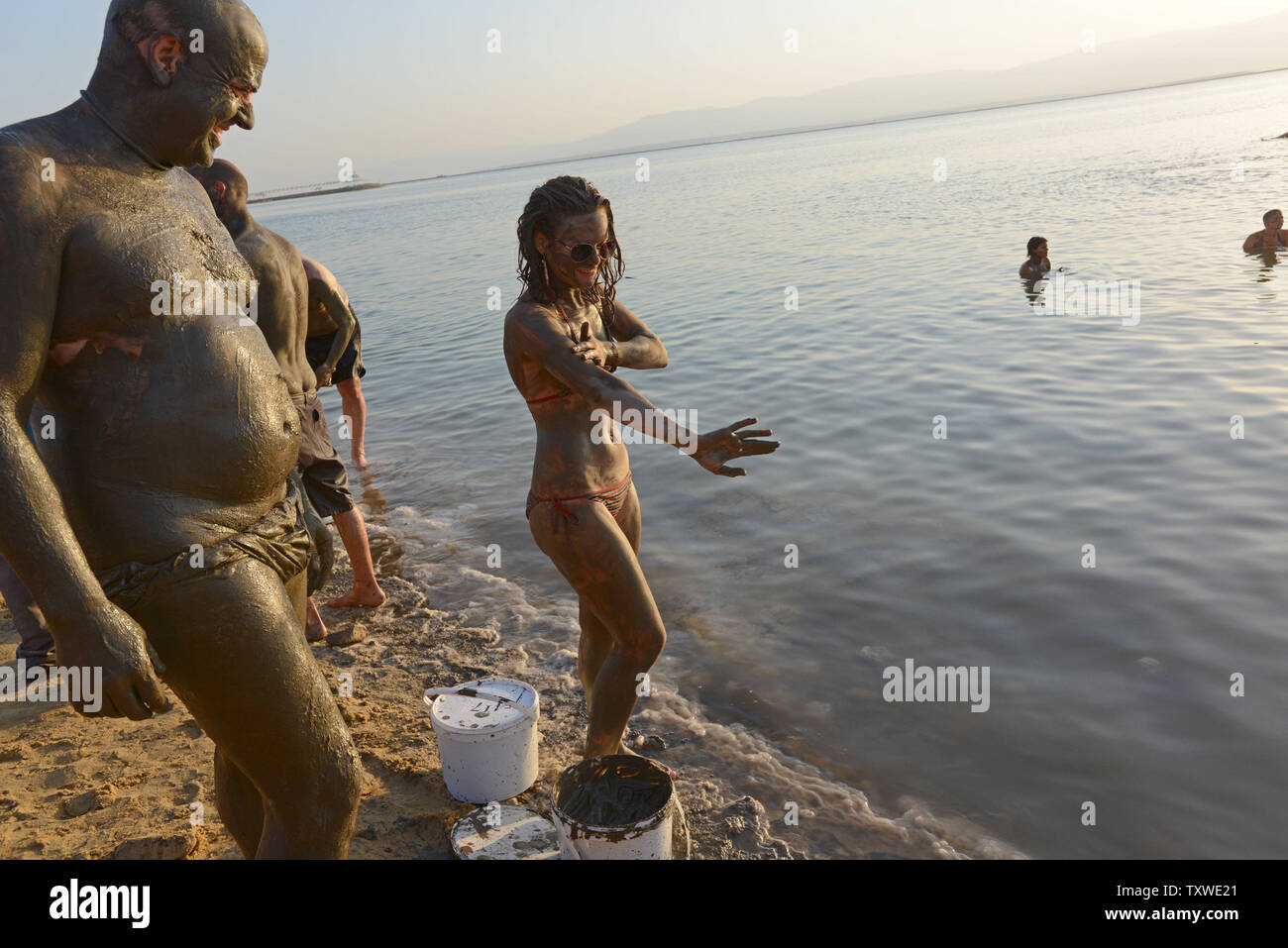 Israeli and international environmental and social activists apply black mud from the Dead Sea during a protest float at dawn against the deterioration of the Dead Sea, in an event organized by U.S. photographer Spencer Tunick, not seen, at Ein Bokek, Israel, September 14, 2012. UPI/Debbie Hill Stock Photo
