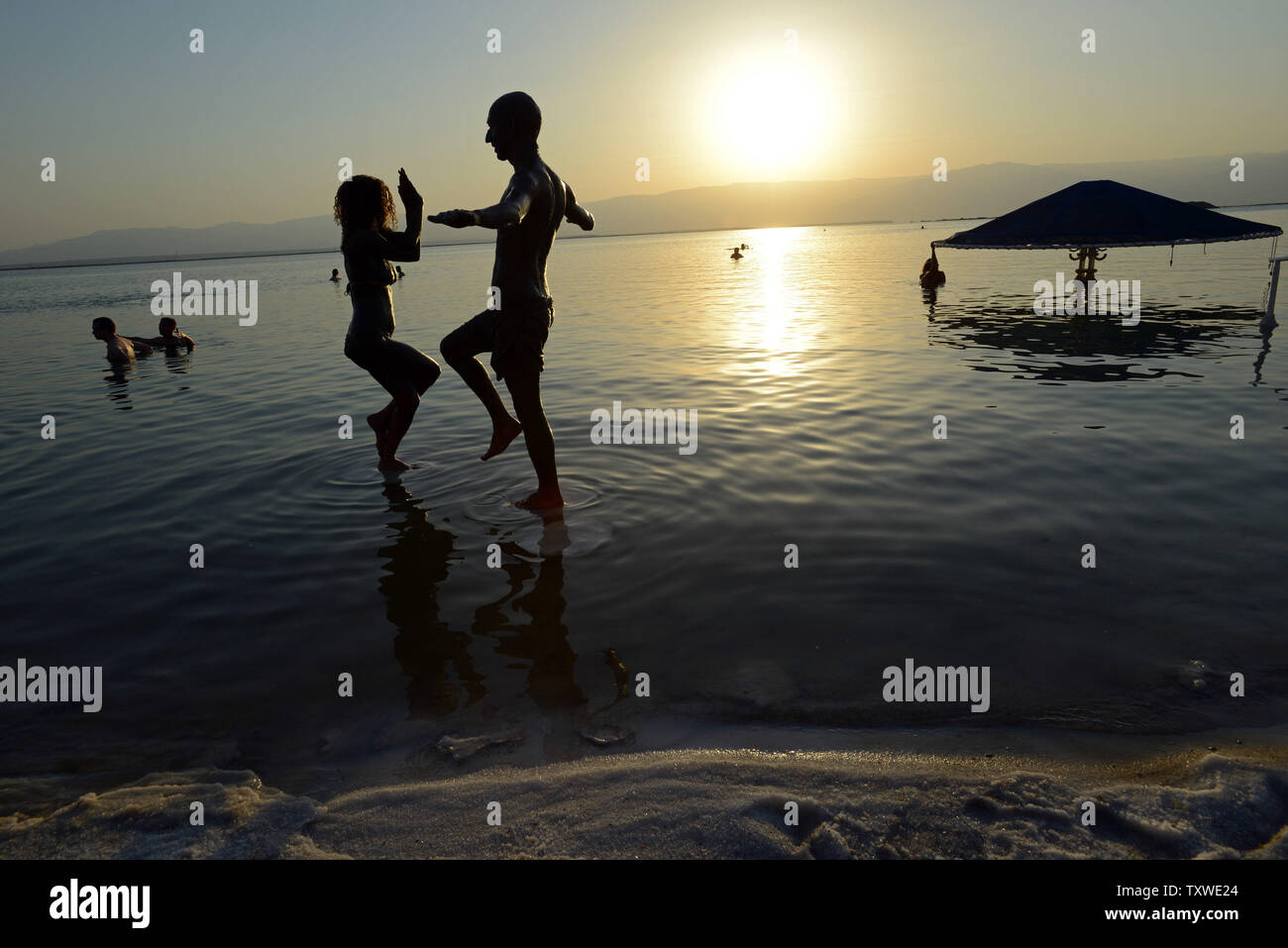 Israelis practice yoga poses on  salt crusts in the Dead Sea during an Israeli and international environmental and  social  protest float at dawn against the deterioration of the Dead Sea,  Ein Bokek, Israel, September 14, 2012.  The  event was organized by U.S. photographer Spencer Tunick.  UPI/Debbie Hill Stock Photo