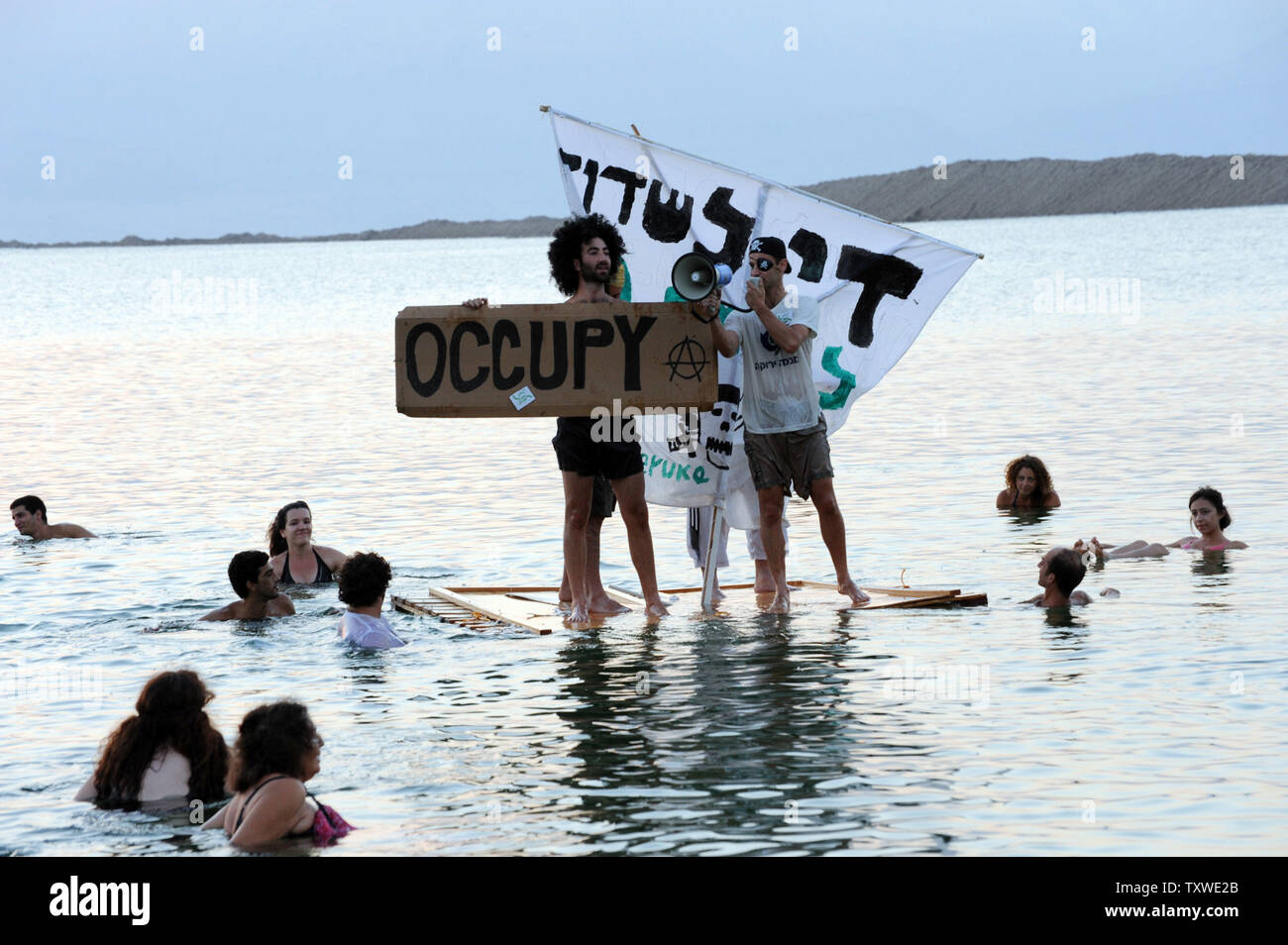 Israeli and international environmental and social activists float on a make-shift pirate ship in the Dead Sea, during a protest float, at dawn, against the deterioration of the Dead Sea, in an event organized by U.S. photographer Spencer Tunick, not seen, at Ein Bokek, Israel, September 14, 2012. UPI/Debbie Hill Stock Photo