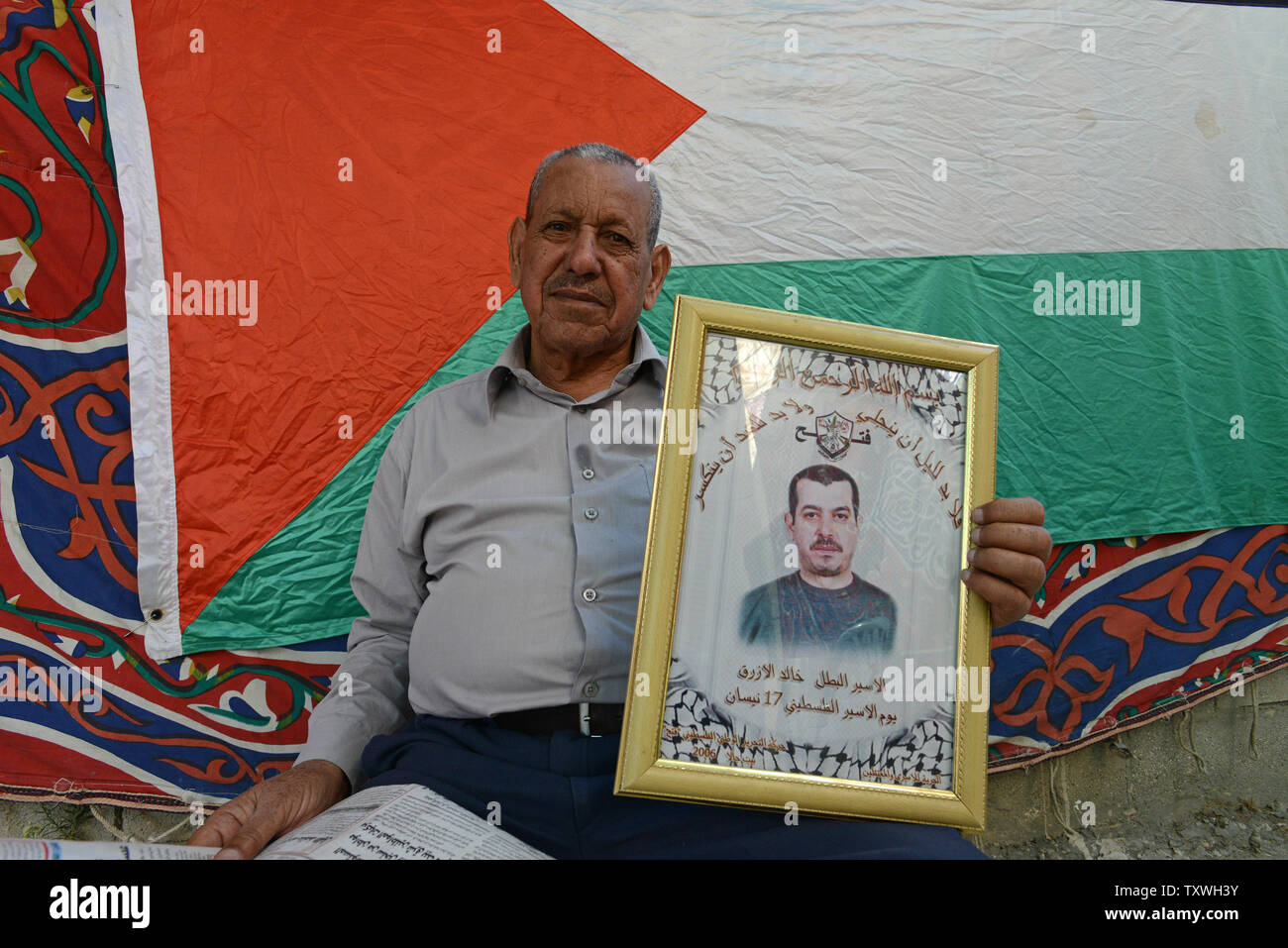 Daoud Azraz holds a photo of his son, Palestinian prisoner Khaled Azraq, who is set to be released from Israeli prison, in his home in the Aida Refugee Camp in Bethlehem, West Bank, October 29, 2013. Azraq, 48 years, has served 24 years in Israeli prison for murdering an Israeli in 1991. He is one of  26 Palestinian prisoners slated for release who killed 30 Israelis prior to the 1993 Oslo Accords.  UPI/Debbie Hill Stock Photo