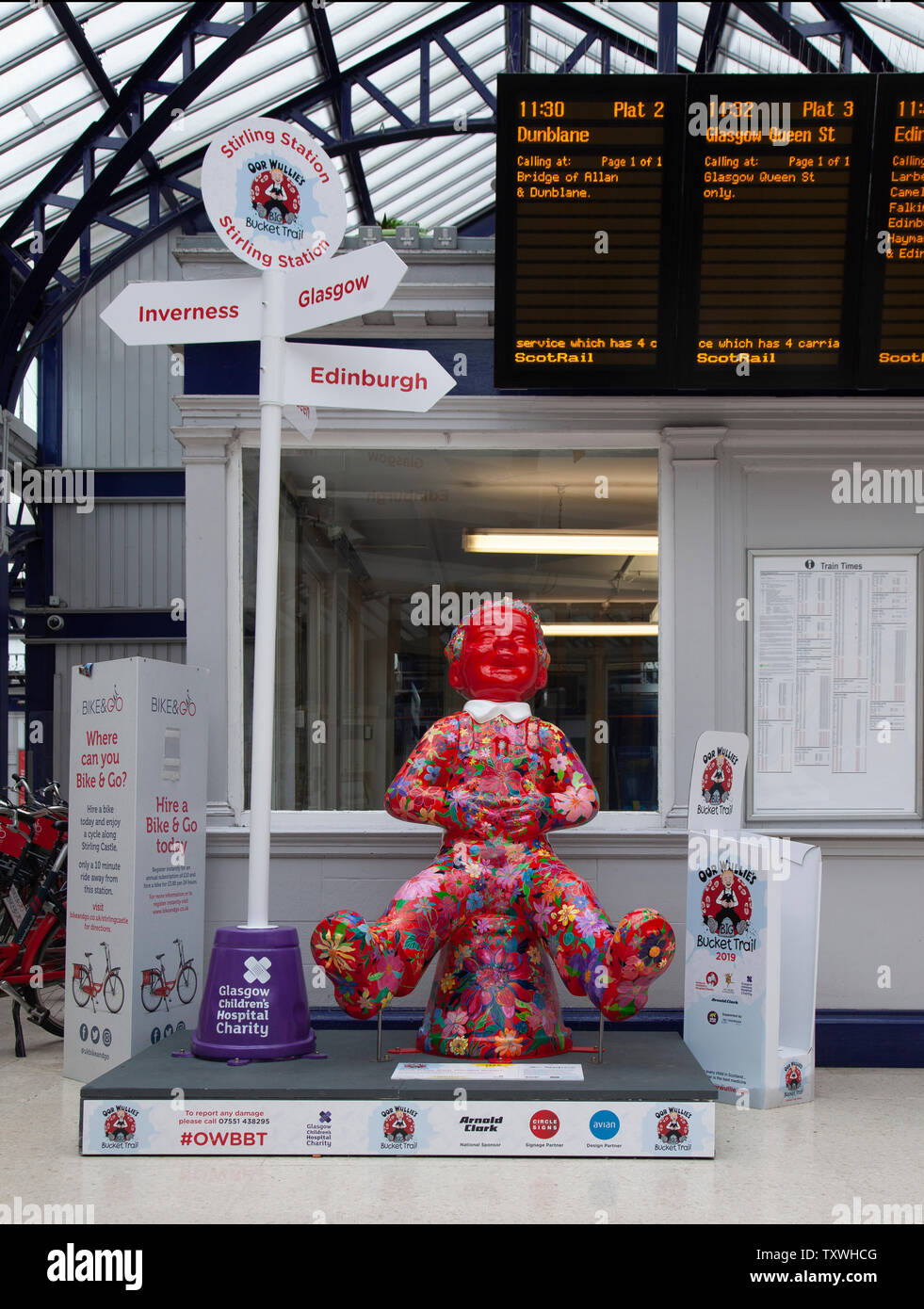 'How does your garden grow?' by Marcella Wylie: Oor Wullie covered in colourful peonies in Stirling Station. Oor Wullie's Big Bucket Trail 2019 Stock Photo