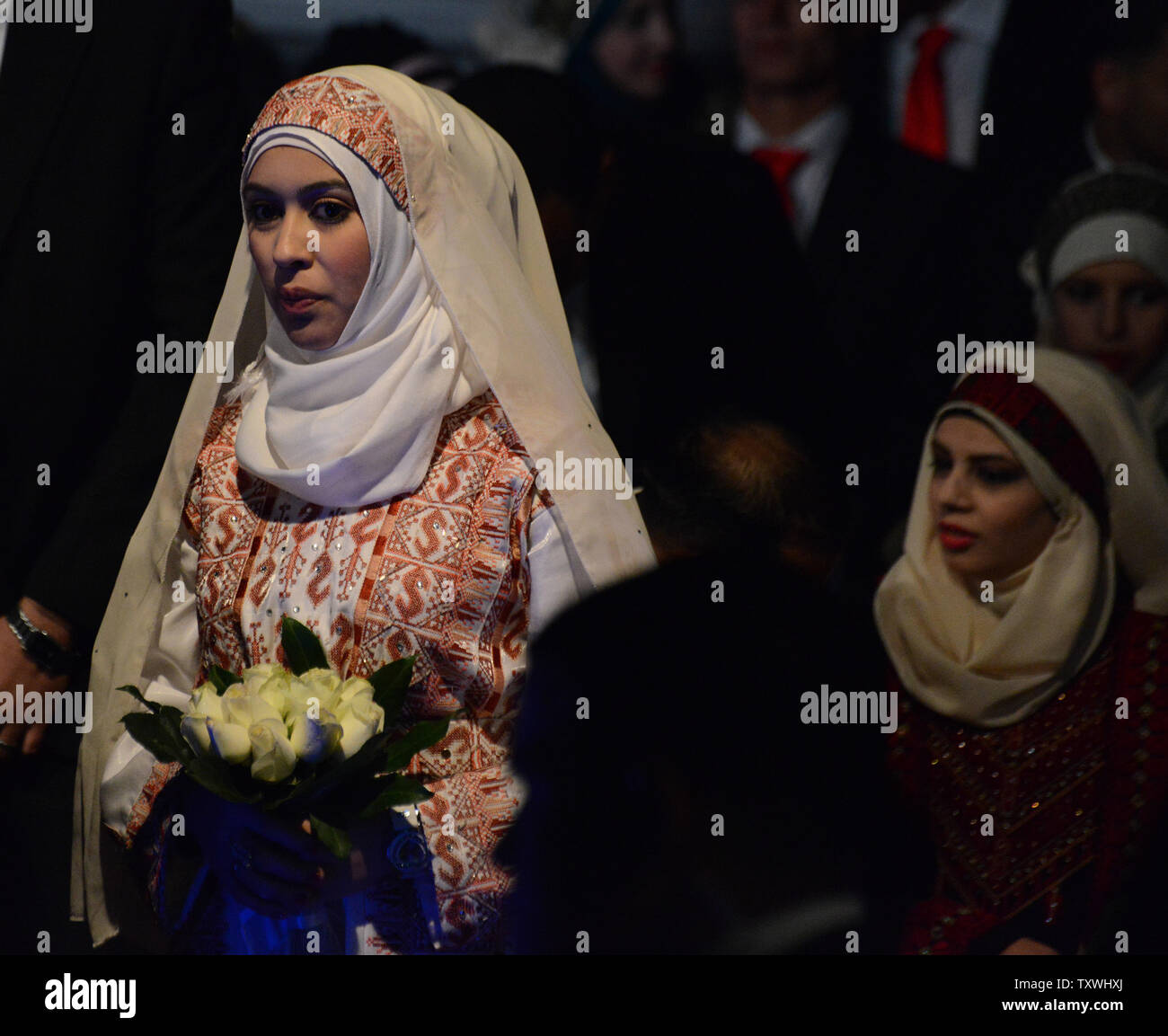 A Palestinian bride holds flowers during a mass wedding of 250 couples, in the presence of Palestinian President Mahmoud Abbas, in Jericho, West Bank, January 28, 2014.  UPI/Debbie Hill Stock Photo