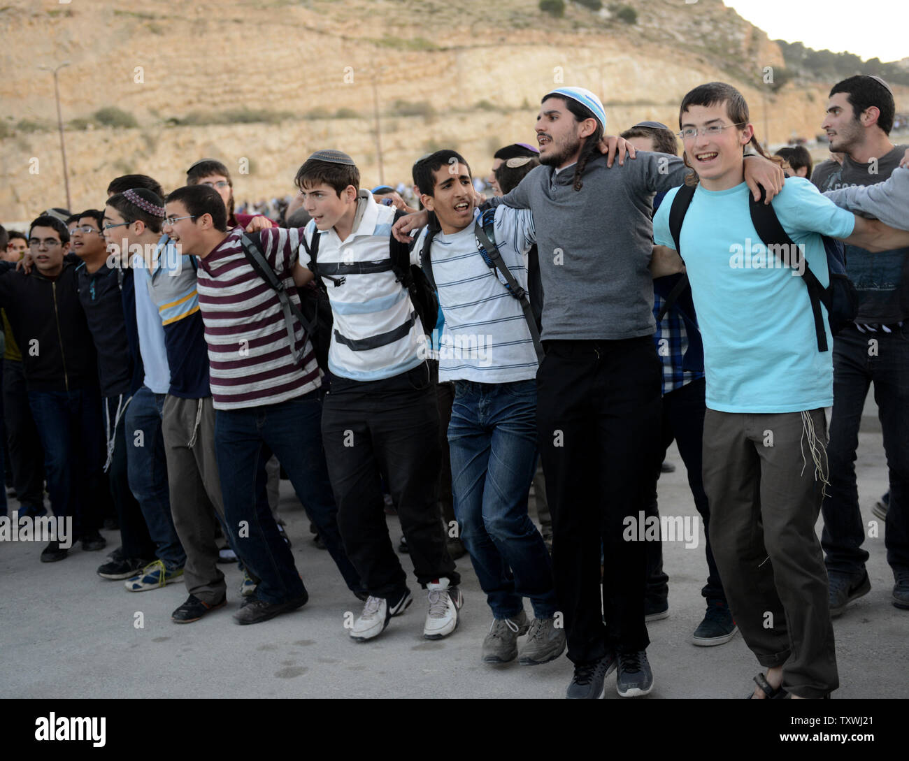 Israeli right-wing settlers chant and dance during a protest calling on the Israeli government to ignore international pressure to freeze settlement building outside the Ma'aleh Adumim Settlement, West Bank, February 13, 2014. The settlers marched to the unbuilt E1 area in the West Bank and demanded that the state build Jewish settlements in the contested area.UPI/Debbie Hill Stock Photo