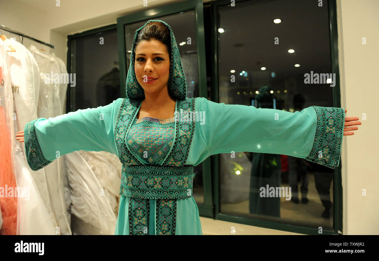 A Palestinian model shows her traditional dress before walking the