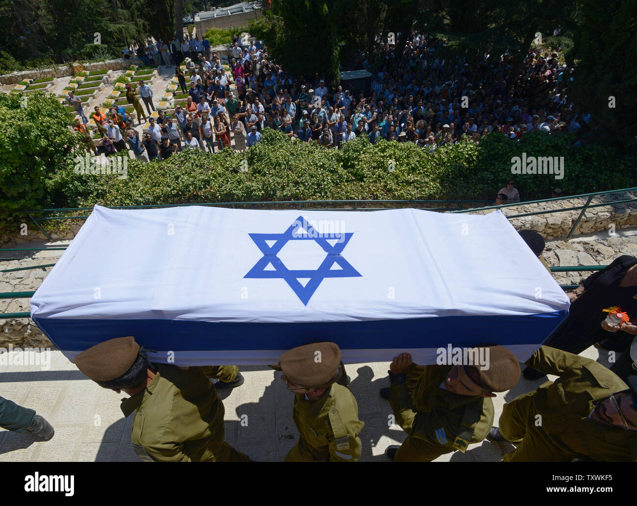 Israeli soldiers carry the flag covered coffin of American-Israeli soldier Max Steinberg, 24, at his funeral in the military cemetery on Mt. Herzl in Jerusalem, Israel, July 23, 2014.  Steinberg, a native of Los Angeles, California, immigrated to Israel and enlisted in the Israel Defense Forces in 2012, where he served as a sharpshooter in the elite Golani Brigade. He was among the 13 soldiers killed by Palestinian militants in the Gaza Strip on Sunday. Twenty-nine Israeli troops have been killed since the army launched a ground incursion into Gaza last week. More than 30,000 people attended t Stock Photo