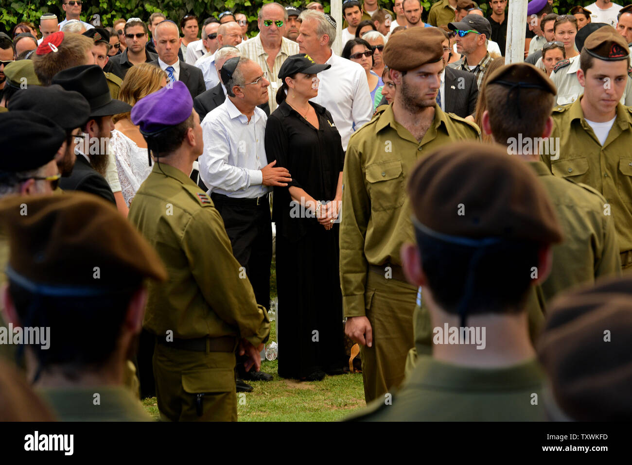 Stuart and Evie Steinberg, from California, attend the funeral of their son, American-Israeli soldier Max Steinberg, 24, in the military cemetery on Mt. Herzl in Jerusalem, Israel, July 23, 2014.  Steinberg, a native of Los Angeles, California, immigrated to Israel and enlisted in the Israel Defense Forces in 2012, where he served as a sharpshooter in the elite Golani Brigade. He was among the 13 soldiers killed by Palestinian militants in the Gaza Strip on Sunday. Twenty-nine Israeli troops have been killed since the army launched a ground incursion into Gaza last week. More than 30,000 peopl Stock Photo