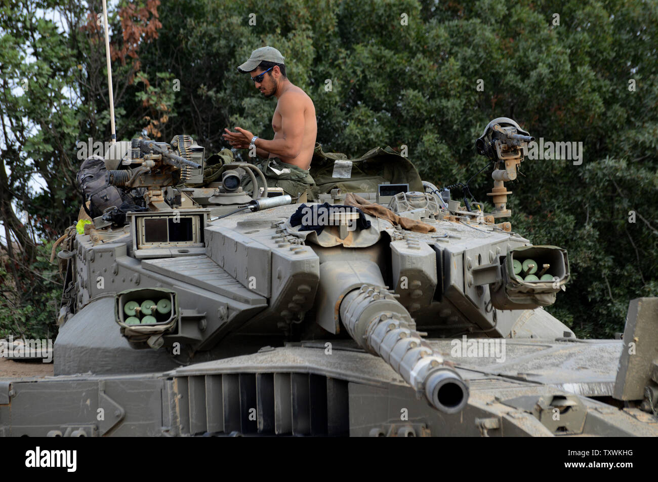 An Israeli soldier works on a merkava tank at a staging area at an unspecified  location near the Israeli border with the Gaza Strip in southern Israel,  July 28, 2014.  Fighting between Israel and Hamas was quieter on the first day of the Muslim holiday of Eid Al Fitr, after pressure from the UN Security Council and US President Barak Obama for an immediate ceasefire.  UPI/Debbie Hill Stock Photo