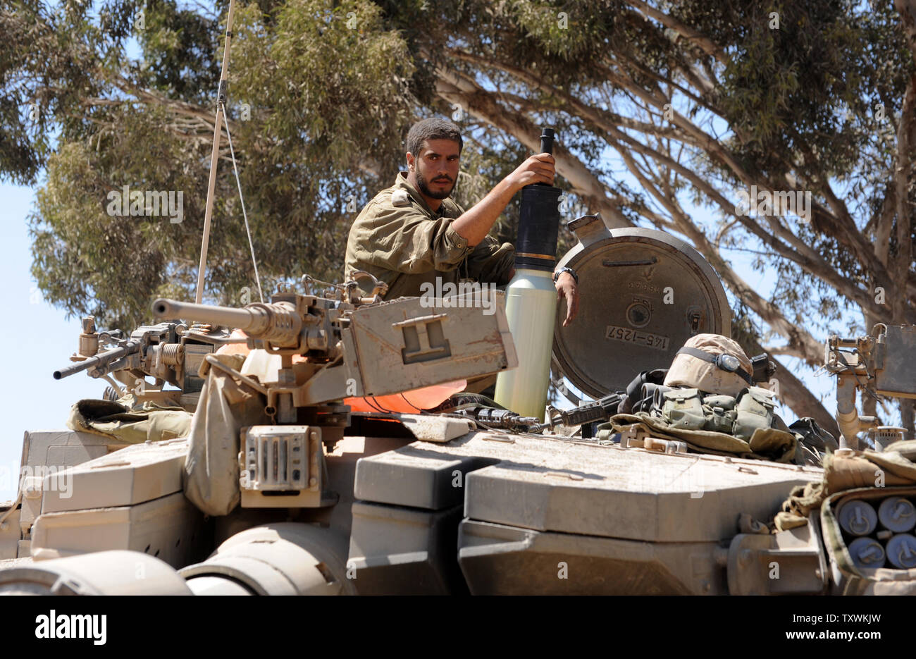 An Israeli soldier holds a shell on top of a Merkava tank at a staging area near the Israel and Hamas controlled Gaza Strip border in southern Israel, July 31, 2014.   UPI/Debbie Hill Stock Photo