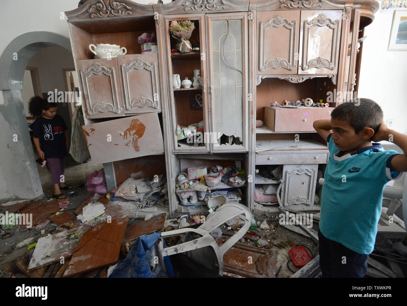 Palestinian children look at damage in her family's house from a direct hit by a Hamas fired rocket from the Gaza Strip, in Beit Sahour near Bethlehem, West Bank, August 5, 2014. The house was hit when Palestinian militants sent a barrage of long range rockets minutes before the 72 hour humanitarian ceasefire went into effect. Israel has completed the withdrawal of troops from Gaza.  UPI/Debbie Hill Stock Photo