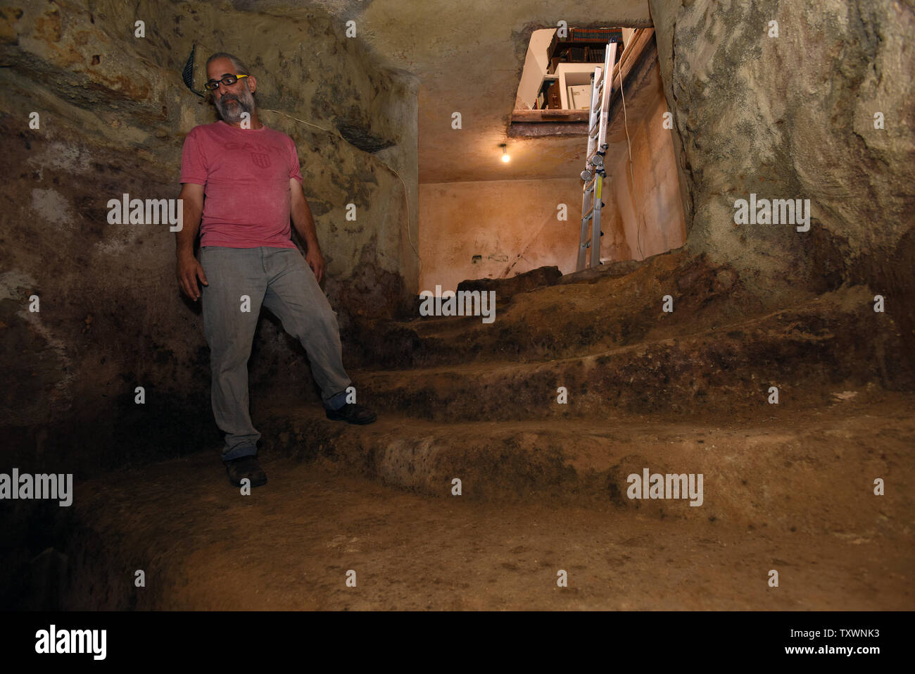 Tal, the owner of the house, stands in a 2,000 year old mikveh, Jewish ritual bath, that was discovered under his living room in the Ein Kerem neighborhood of Jerusalem, Israel, during renovations, July 1, 2015. The Israeli owners of the private house discovered a pair of wooden doors beneath a rug which led to the ancient ritual bath. Archeologist say the discovery is important since Ein Kerem is considered a place sacred to Christianity where according to the New Testament, John the Baptist was born and where his pregnant mother Elizabeth met Mary, mother of Jesus. The discovery of the ritua Stock Photo