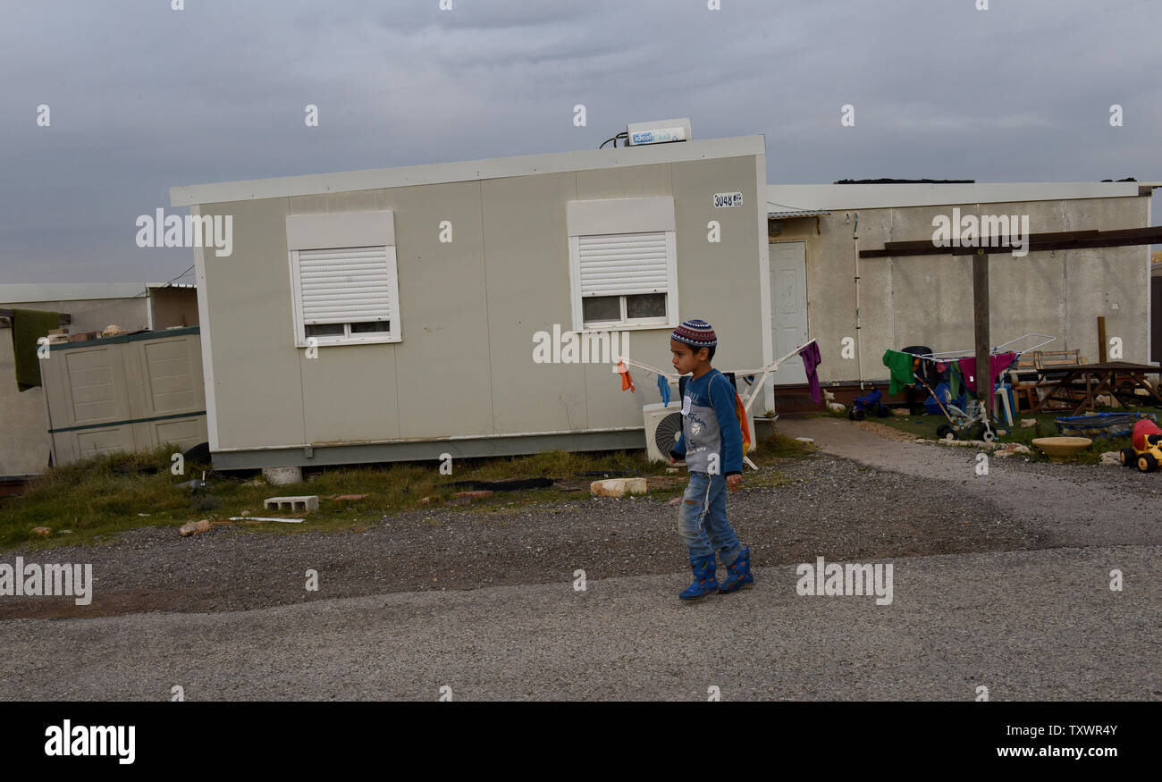 An Israeli boy walks by a caravan home in the Jewish settlement Eli in