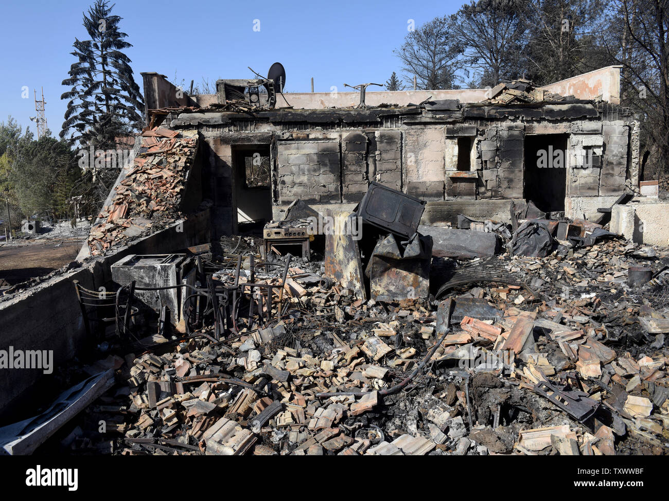 Ther charred remains of a house house destroyed by a fire stand in the Jewish settlement Hamalish in the West Bank, November 27, 2016. Several firebombs were found in the area of the settlement where forty-five homes were damaged and eighteen completely destroyed. More than a dozen suspects have been arrested for intentionally lighting fires that have ravished Israel and the West Bank. Israeli Prime Minister Benjamin Netanyahu and members of his hardline government have accused Palestinians of lightening the fires. Some 560 homes were burnt across the country while Palestinian firefighters joi Stock Photo