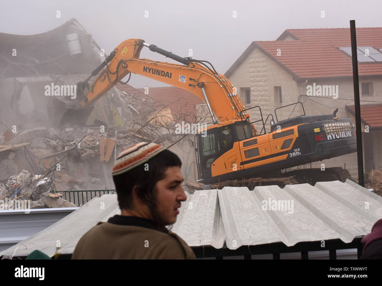 Israeli settlers watch a bulldozer demolish a house in the Ofra Settlement in the West Bank near Ramallah,  March 1, 2017. Israeli forces are demolishing nine Jewish homes in the Ofra Settlement after the Supreme Court ruled they were  built on private Palestinian land.  Photo by Debbie Hill/UPI Stock Photo