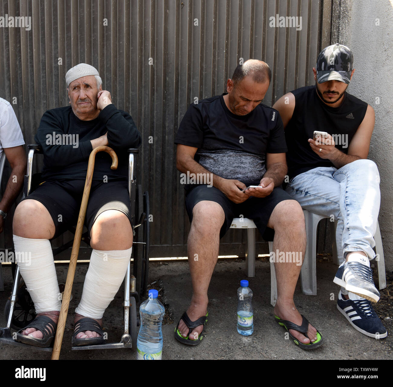 Palestinian Ayoub Shamsaneh, 84,(L) sits with his son, Mohammad (C) on the  street outside their home of fifty-three years, after being evicted by  Israeli police Tuesday morning, in Sheikh Jarrah, East Jerusalem,