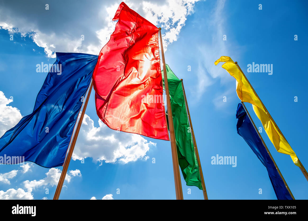 Colorful flags in the wind against the blue sky background Stock Photo ...