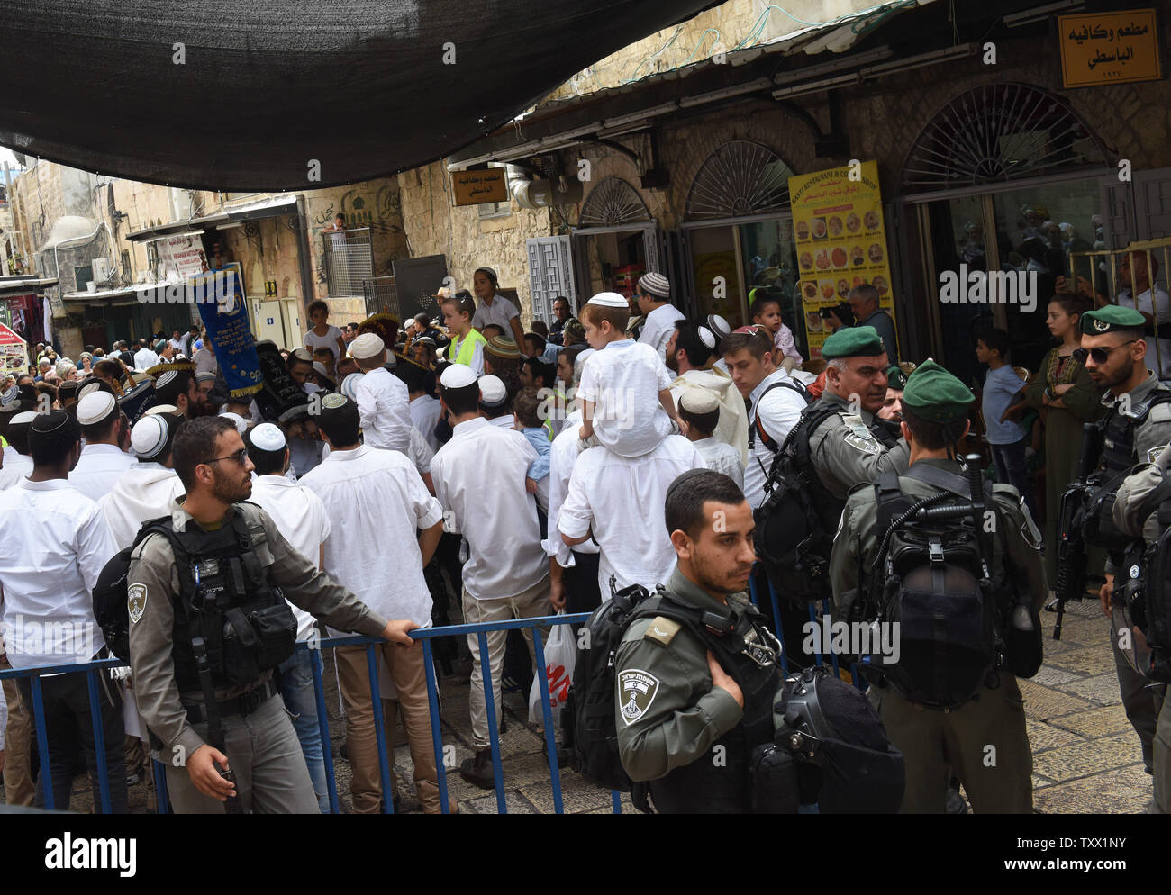 Israeli border police guard Orthodox Jewish settlers as they sing and dance with Torah scrolls on Simchat Torah in the Muslim Quarter of  Jerusalem's Old City, October 1, 2018. Simchat Torah is a Jewish holiday that celebrates the conclusion of the annual cycle of Torah readings, which follows immediately after the festival of Sukkot.   Photo by Debbie Hill/UPI Stock Photo