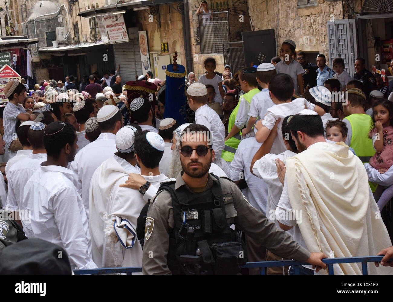 Israeli border police guard Orthodox Jewish settlers as they sing and dance with Torah scrolls on Simchat Torah in the Muslim Quarter of  Jerusalem's Old City, October 1, 2018. Simchat Torah is a Jewish holiday that celebrates the conclusion of the annual cycle of Torah readings, which follows immediately after the festival of Sukkot.   Photo by Debbie Hill/UPI Stock Photo